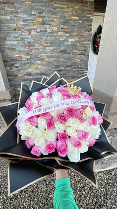 someone is holding a bouquet of flowers in front of a star on the ground outside