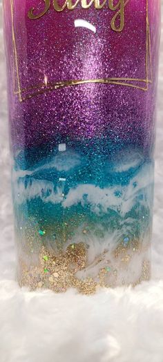 there is a purple and blue bottle with glitter on it