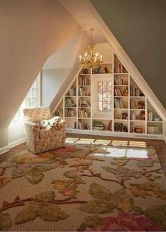 a living room with an attic style bookcase in the corner and a chandelier hanging from the ceiling