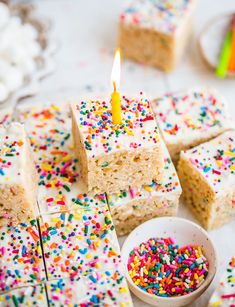 several pieces of cake with sprinkles and a lit candle