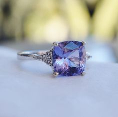 a tanzante and diamond ring sitting on top of a table