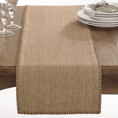 the table is set with place settings and silverware, along with a linen runner