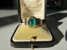 This is a beautiful vintage 3.96 carat (estimated based on measurements) natural cabochon emerald with 16 gorgeous blue square cut sapphires channel set down the shoulders in an 18k gold setting. The color of the stone is a deep, rich green with natural inclusions (jardin) inherent in most emeralds. The cool colors of the gemstones in rich and weighty 18k gold make this a real stunner on the finger. Very good vintage condition. There are some abrasions to the emerald from wear (see pics and note Cabochon Emerald Ring, Antique Ring Box, Emerald Cabochon, Platinum Diamond Engagement Rings, Wide Band Ring, Cool Colors, Coral Ring, Rich Green, Wide Band Rings