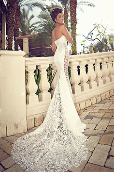 a woman in a wedding dress standing on a balcony