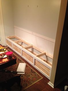 a living room filled with furniture and lots of storage under the window sill on top of a rug