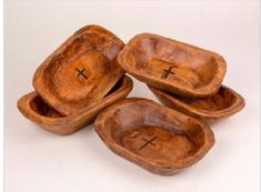 four wooden bowls with crosses on them sitting next to each other in front of a white background