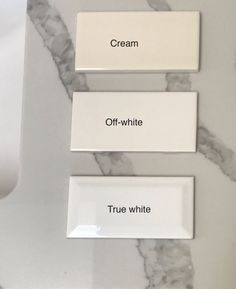 three white plates sitting on top of a marble counter