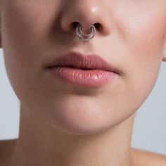 a woman with a nose ring on her nose and piercing in the shape of an occupant