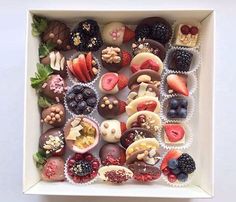 a box filled with assorted chocolates and fruit on top of eachother