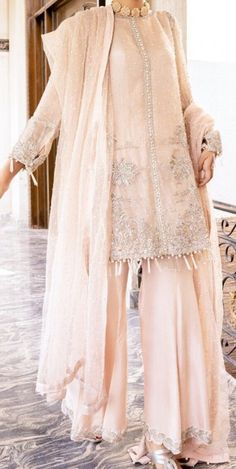 Timeless and exquisite, this powder pink organza shirt is hand embellished with statement sleeves. Paired with raw silk Gharara pants and an organza dupatta with sitara spray ? the dress is a perfect wear for a soiree. Glamorous Hand Embellished Organza Sharara, Glamorous Organza Sets With Pearl Embroidery, Glamorous Georgette Palazzo Set For Eid, Glamorous Organza Sharara For Festive Occasions, Glamorous Designer Organza Dresses, Glamorous Festive Organza Sharara, Embellished Organza Sharara In Glamorous Style, Glamorous Sharara With Sheer Dupatta For Eid, Glamorous Embellished Organza Sharara