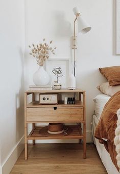 a bed room with a neatly made bed and a night stand next to the bed