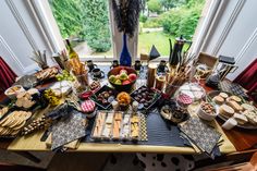 a table filled with lots of food next to a window