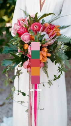 a woman wearing a white dress holding a colorful bouquet with pink and orange flowers on it