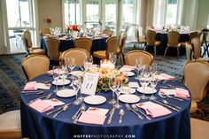 a table set up with place settings and flowers on it for a formal dinner party