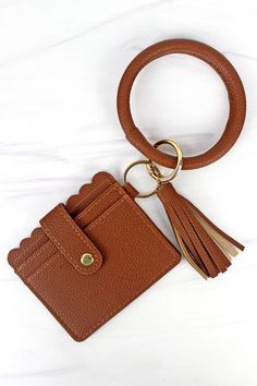 a brown leather keychain with a tassel hanging from it's side