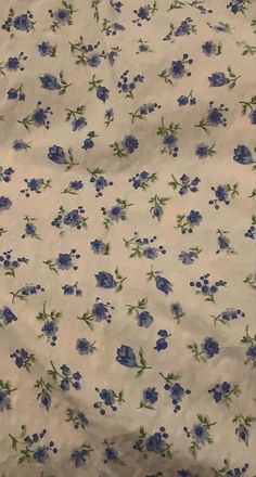 a blue and white flowered fabric with green leaves on it's side,