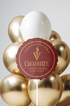 gold balloons are arranged in the shape of a graduation sign with a red ribbon on top