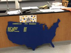 an office desk with a sign on it that says american fea degrees and the map of the united states