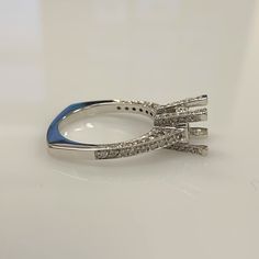 a blue and white diamond ring sitting on top of a table