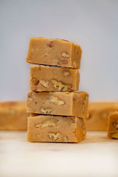 five pieces of peanut butter fudge are stacked on top of each other with nuts