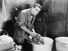 a man is washing dishes in buckets