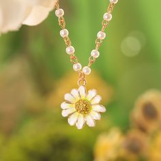 The Daisy Pearl Necklace is a perfect embodiment of elegance and playful charm. Crafted with a radiant enamel daisy pendant, the daisy flower necklace features delicate pearl accents on a gold-plated chain, creating a timeless blend of nature and sophistication. The daisy, with its luminous white petals and golden center, captures the essence of fresh beauty, while the pearls add a touch of classic grace. Ideal for those who adore  nature-inspired jewelry , this piece is both whimsical and versa Daisy Pearl Necklace, Brass Pendant Necklace, Astrology Jewelry, Astrology Necklace, Daisy Pendant, Daisy Jewelry, White Petals, Moon And Star Ring, Fresh Beauty