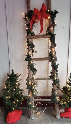 an old ladder decorated with christmas trees and lights