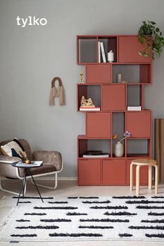 a living room filled with furniture and a book shelf next to a chair on top of a rug