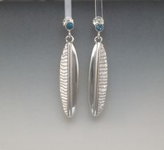 Contrasting textures are the name of the game in these elegant drop earrings. The drops are individually cast from hand carved cuttlefish bone molds in sterling silver - the molds are burned up in the process so each one is unique. The resulting silver castings perfectly replicate the texture of the cuttlefish bone. I then selectively file and sand off the texture and bring those areas to a high polish to accentuate the contrast. A half round sterling silver wire is added along the centerline of Carved Sterling Silver Earrings, Pebble Jewelry, Silver Casting, Traverse City Mi, Fish Jewelry, Bone Jewelry, Oval Earrings, Casting Jewelry, Oval Earring