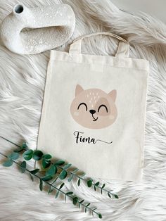 a tote bag sitting on top of a white fur covered floor next to a plant