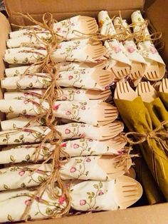 wooden utensils are in a box with floral designs and ribbons tied around them