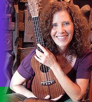 a woman sitting on a chair with a guitar in front of her and a dog statue behind her