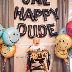 a baby sitting in a chair with balloons around him and the words one happy dude on it