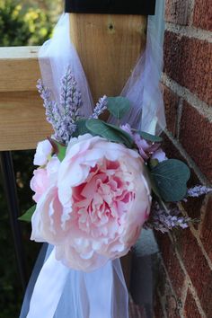 a bridal bouquet hanging from the side of a brick wall next to a door