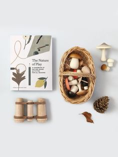 a basket filled with lots of different types of mushrooms next to some sort of book