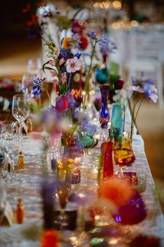 a table topped with lots of colorful vases filled with different types of glassware