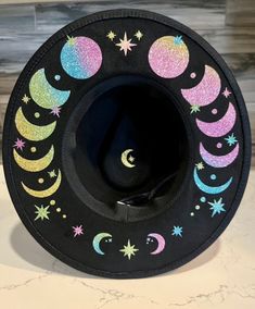 A sturdy thick 100% polyester hat. I have applied glitter rainbow moon phases and stars. Get your witchy vibe on. It has adjuster inside. Size M/L Circumference 22.8 inches 4 inch brim Moon Hat, Custom Cowboy Hats, Rainbow Accessories, Witch Moon, Glitter Rainbow, Painted Hats, Hat Wide Brim, Witchy Fashion, Wide Brim Fedora