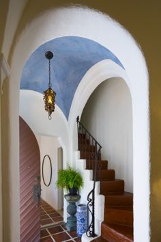 an archway leading to a hallway with potted plants