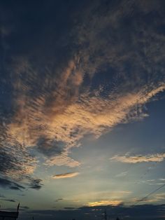 the sun is setting behind some clouds in the sky