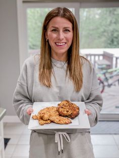 a woman holding a plate with some food on it