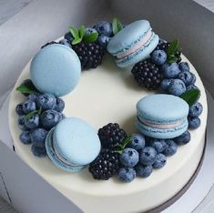 a cake decorated with macaroons and blueberries is shown on the instagram page