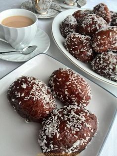 two plates filled with pastries next to a cup of coffee