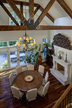 a dining room table with white chairs and a chandelier hanging from the ceiling