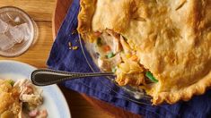 there is a pie on the table with a fork in it and a glass of water next to it