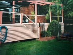 a house with a metal railing and green grass