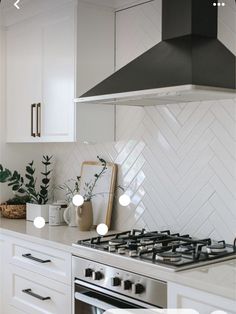 a stove top oven sitting inside of a kitchen next to white cupboards and drawers