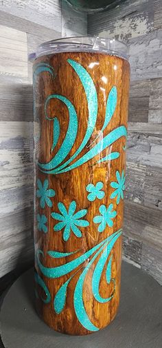 a wooden cup with blue flowers painted on it