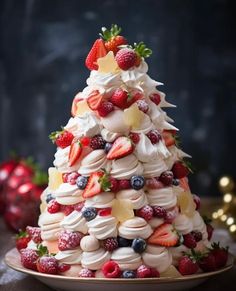 a small christmas tree made out of meringue and strawberries on a plate