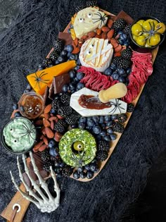 a platter with halloween food on it, including grapes, cheeses and crackers