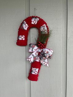 a red christmas wreath hanging on the side of a white door with santa clause decorations